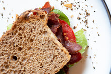 Load image into Gallery viewer, a biltong, lettuce and tomato sandwich on wheat bread closeup
